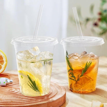 Pack of 100 - 16 oz clear plastic disposable iced coffee cups with lids.